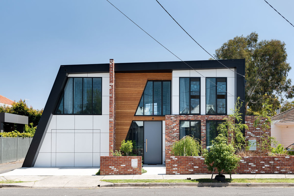 Mittelgroßes, Zweistöckiges Modernes Einfamilienhaus mit Metallfassade, schwarzer Fassadenfarbe, Flachdach und Blechdach in Melbourne