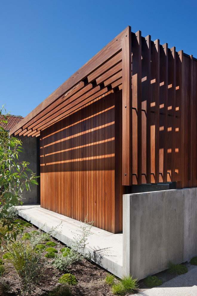 This is an example of a contemporary bungalow house exterior in Melbourne with wood cladding.