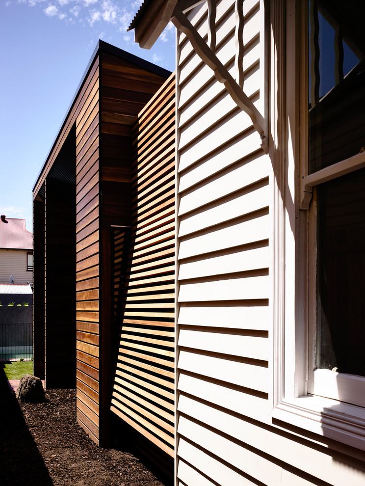 Foto de fachada blanca actual pequeña de una planta con revestimiento de madera y tejado a dos aguas