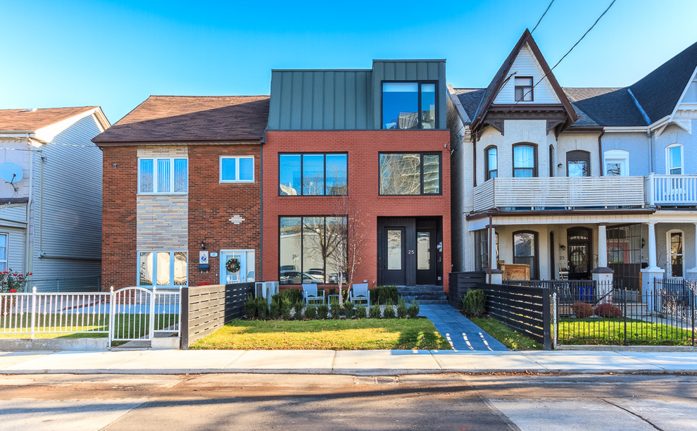 Photo of a medium sized and red contemporary brick house exterior in Toronto with three floors and a flat roof.