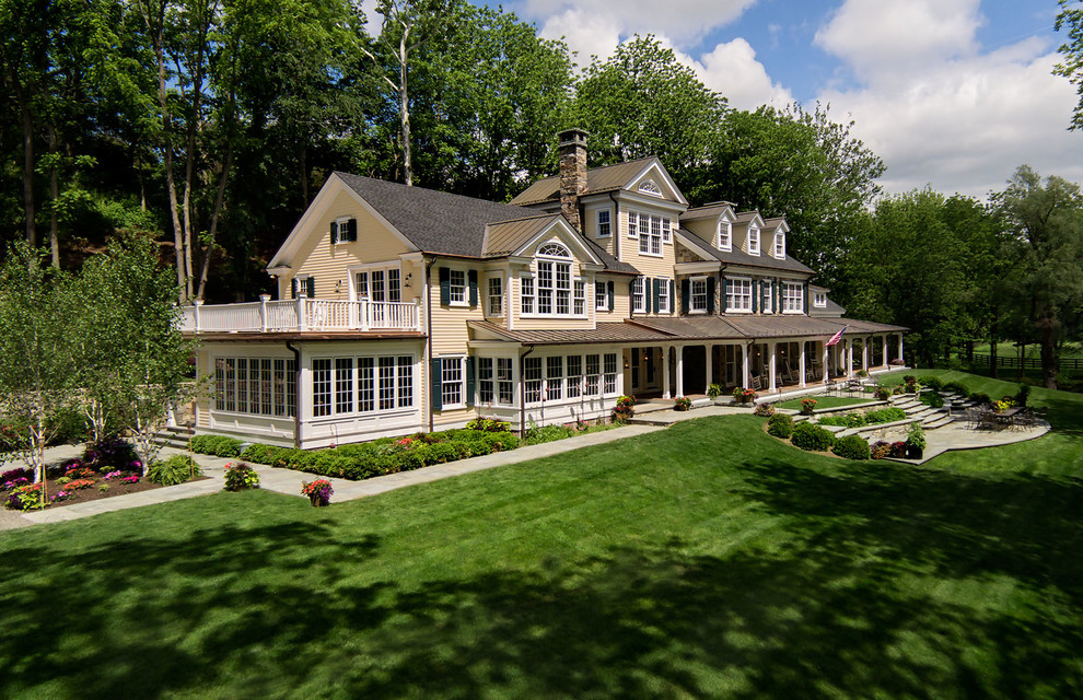 Huge farmhouse yellow three-story wood exterior home photo in New York with a shingle roof