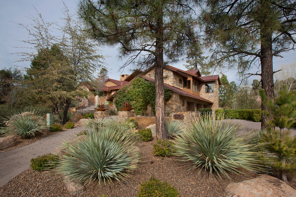 Mittelgroßes Rustikales Haus mit Steinfassade, brauner Fassadenfarbe und Satteldach in Phoenix