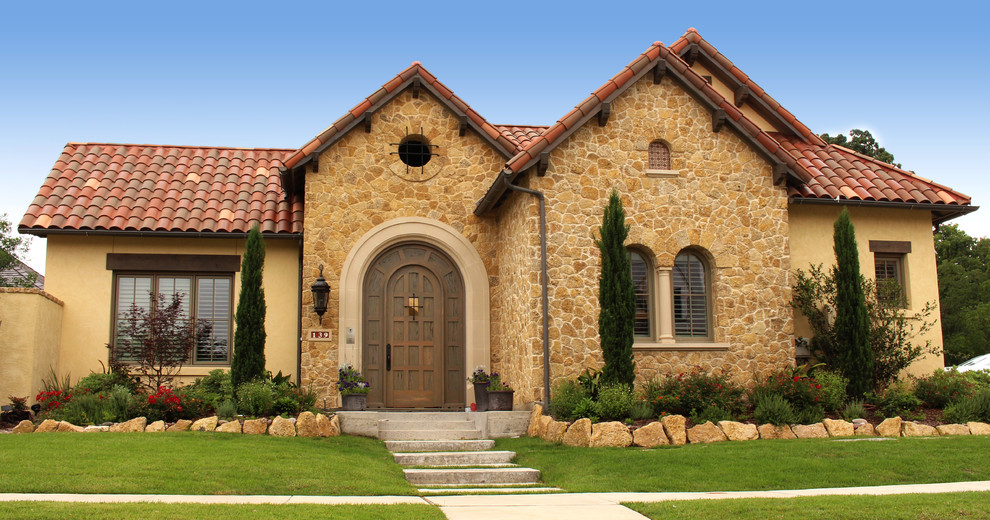 Einstöckiges, Mittelgroßes Haus mit Steinfassade und gelber Fassadenfarbe in Dallas