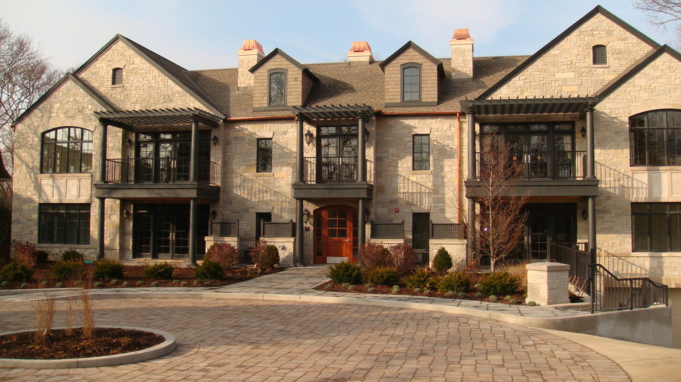 Large elegant beige two-story stone exterior home photo in Chicago with a shingle roof