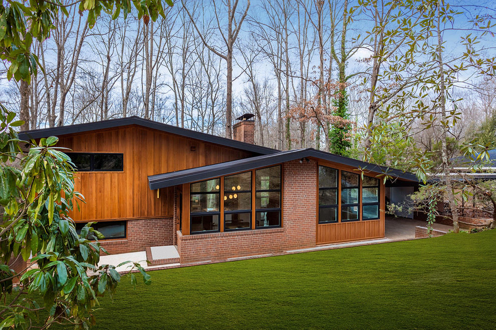 Стильный дизайн: большой, деревянный, коричневый частный загородный дом в стиле ретро с разными уровнями, плоской крышей и металлической крышей - последний тренд