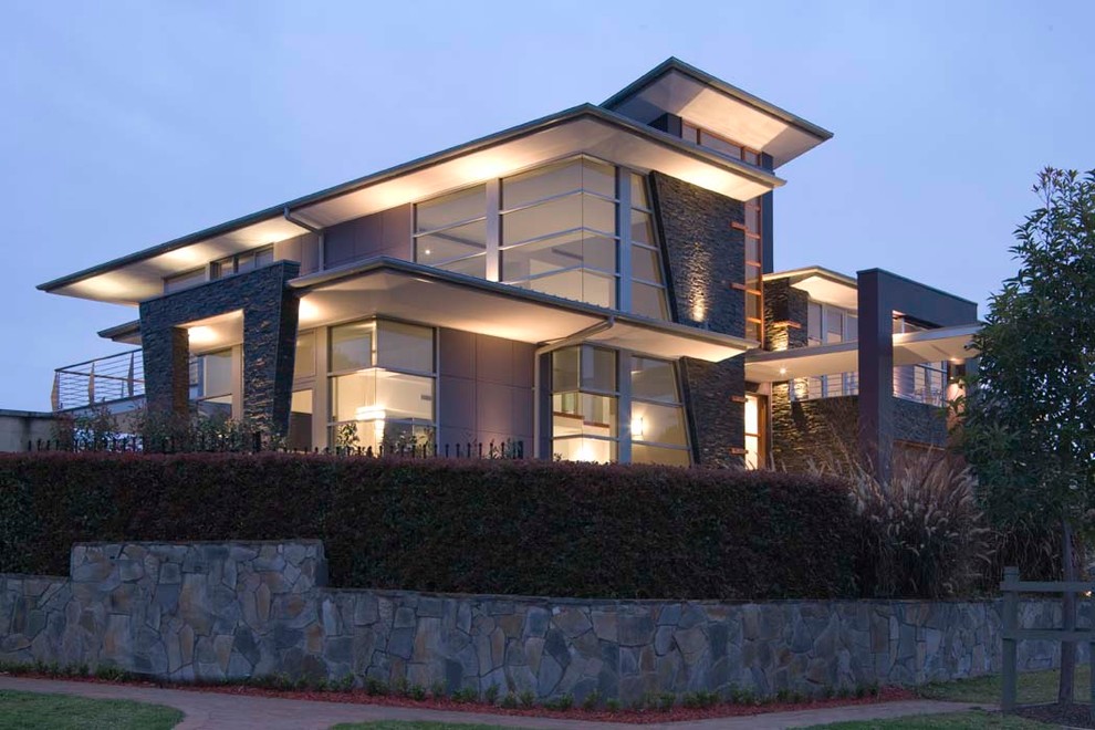 Exemple d'une très grande façade de maison multicolore tendance à un étage avec un revêtement mixte, un toit plat et un toit en métal.
