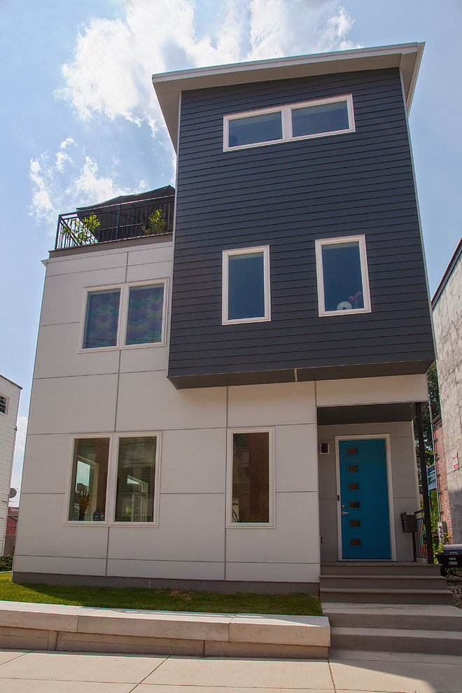 Cette photo montre une façade de maison tendance en planches et couvre-joints à deux étages et plus avec un toit plat et un toit mixte.