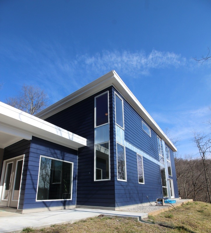 На фото: двухэтажный, синий дом среднего размера в стиле модернизм с облицовкой из винила и плоской крышей