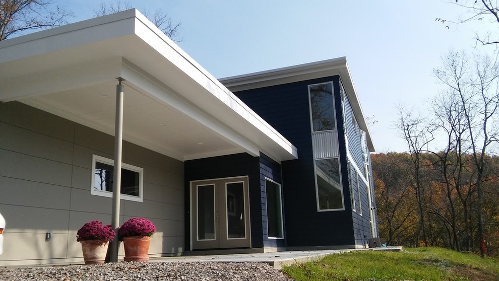 Inspiration for a mid-sized modern blue two-story vinyl flat roof remodel in Cincinnati