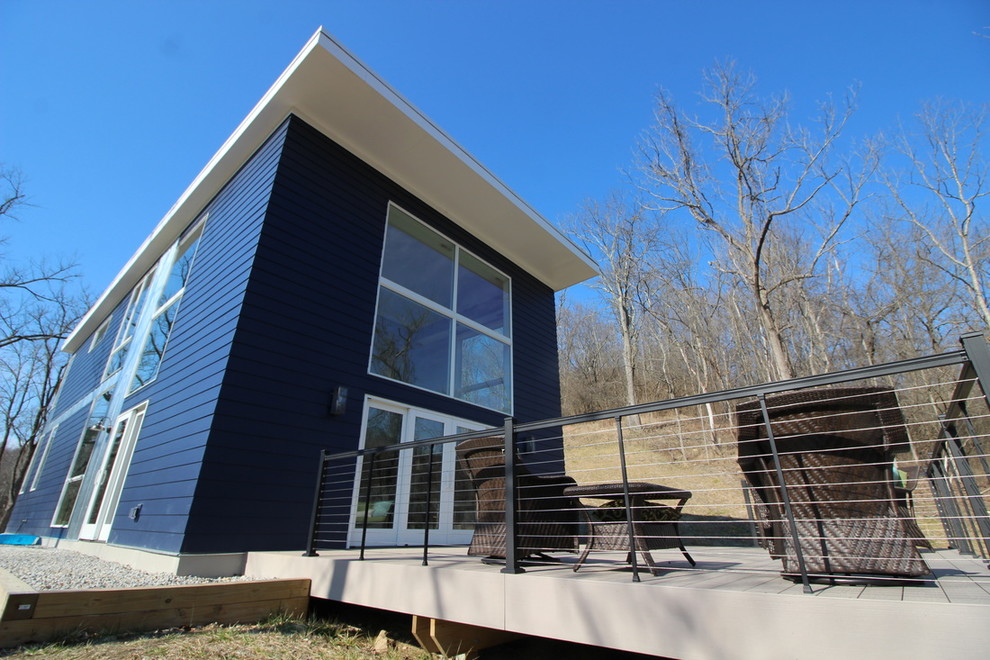 Стильный дизайн: двухэтажный, синий дом среднего размера в стиле модернизм с облицовкой из винила и плоской крышей - последний тренд