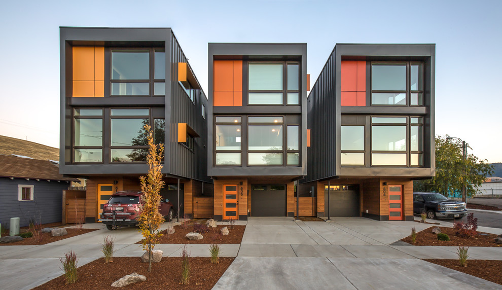 Kleines, Dreistöckiges Modernes Reihenhaus mit Metallfassade, grauer Fassadenfarbe und Flachdach in Sonstige
