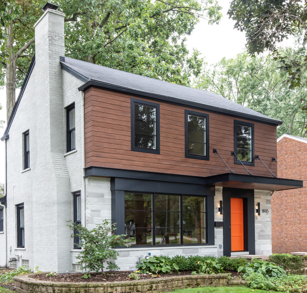 Ejemplo de fachada de casa multicolor retro de tamaño medio de dos plantas con revestimientos combinados, tejado a dos aguas y tejado de teja de madera
