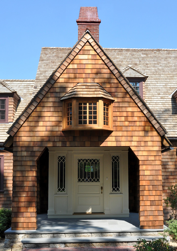 Ejemplo de fachada marrón clásica grande de tres plantas con revestimiento de madera y tejado a dos aguas
