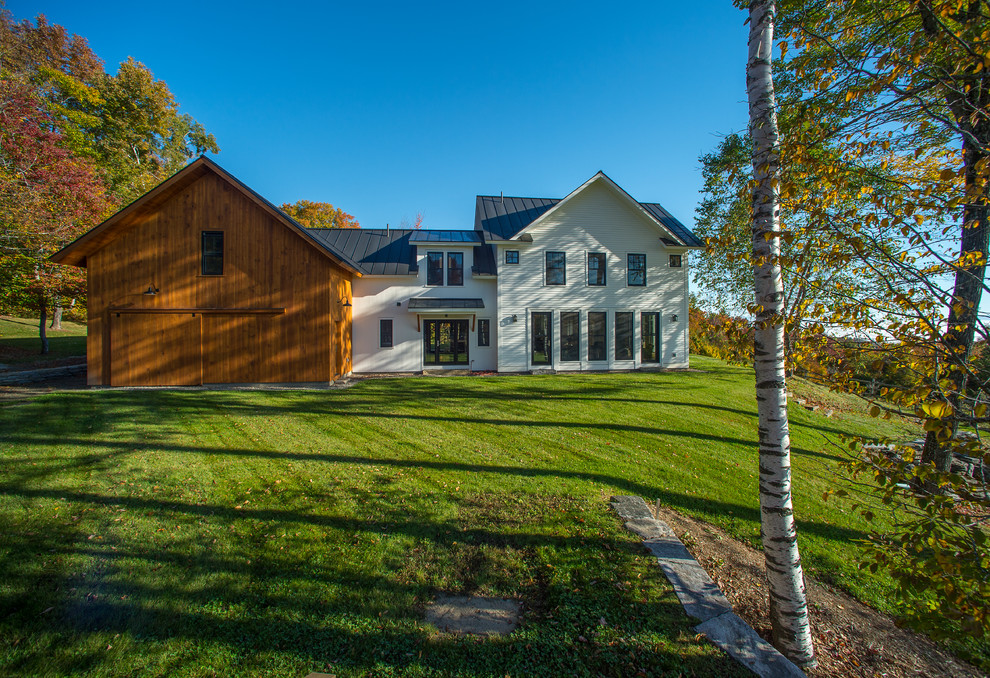 Großes, Zweistöckiges Landhausstil Haus mit Vinylfassade, weißer Fassadenfarbe und Satteldach in Burlington