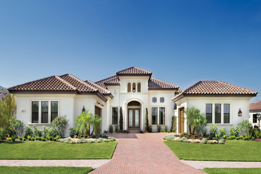 Example of a huge tuscan one-story stucco exterior home design in Tampa