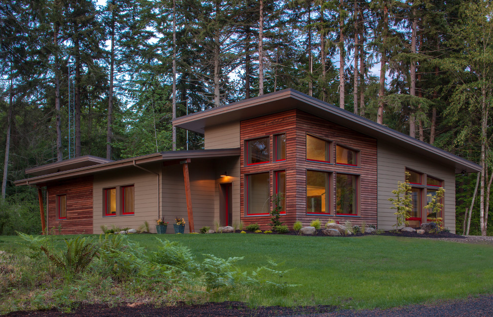 Foto della facciata di una casa grande marrone contemporanea a un piano con rivestimento in legno e copertura a scandole