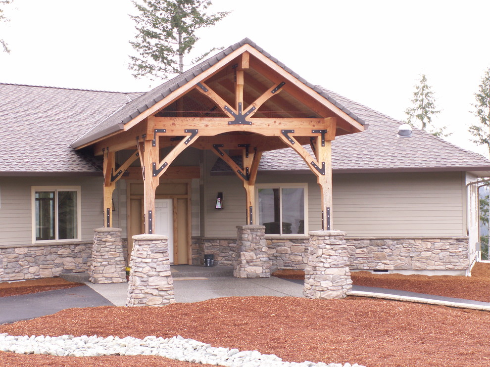Esempio della facciata di una casa grande beige american style a un piano con rivestimenti misti e tetto a capanna