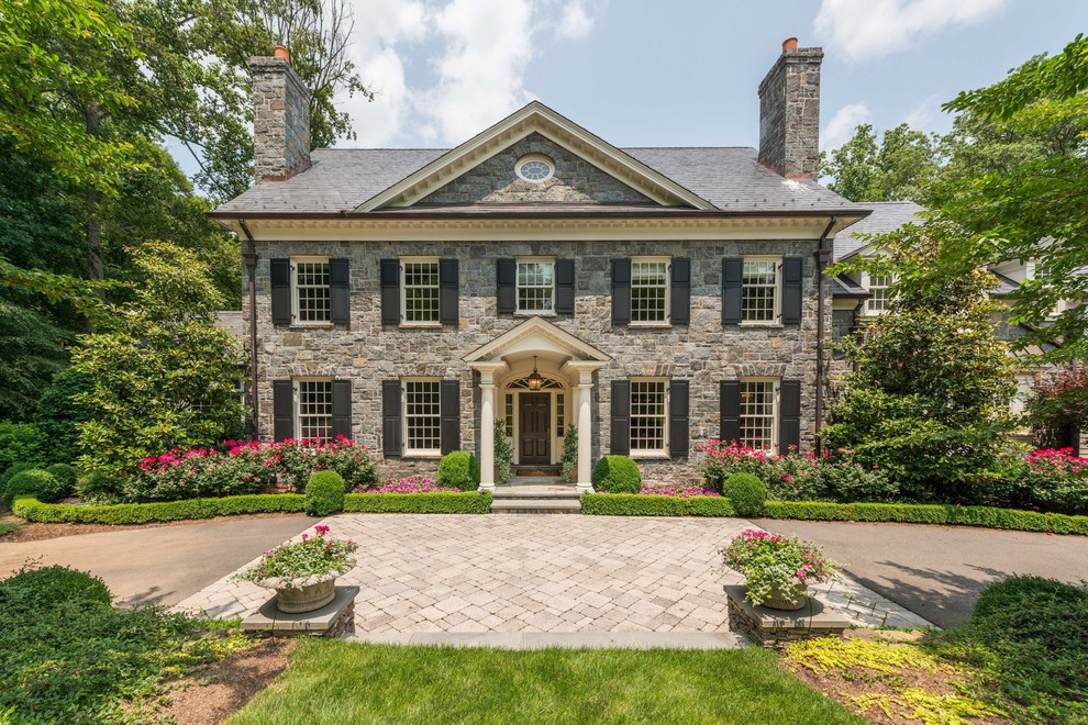 Large classic house exterior in DC Metro with stone cladding and a hip roof.