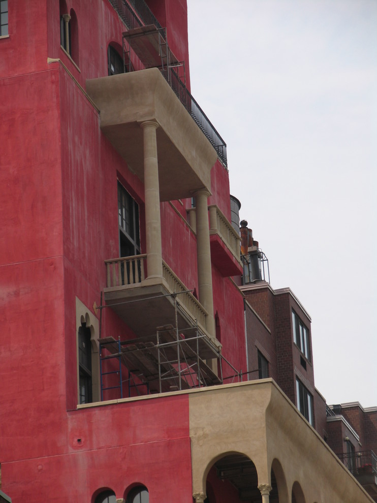 На фото: большой, трехэтажный, красный дом в стиле фьюжн с комбинированной облицовкой с