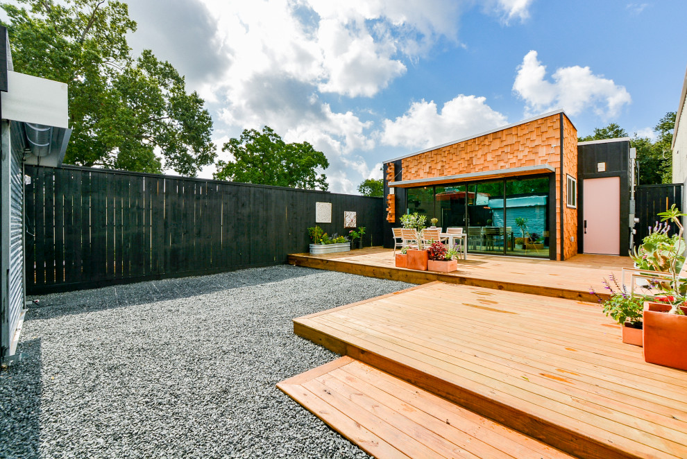 Стильный дизайн: маленький, одноэтажный, черный частный загородный дом в стиле фьюжн с облицовкой из ЦСП, односкатной крышей и крышей из смешанных материалов для на участке и в саду - последний тренд