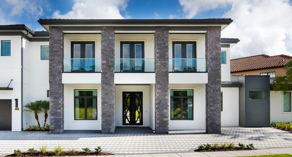 Diseño de fachada blanca minimalista grande de dos plantas con revestimiento de estuco y tejado plano