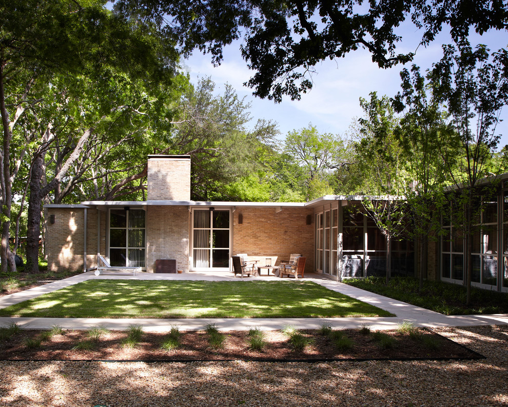 Large and red midcentury bungalow brick detached house in Dallas with a flat roof.