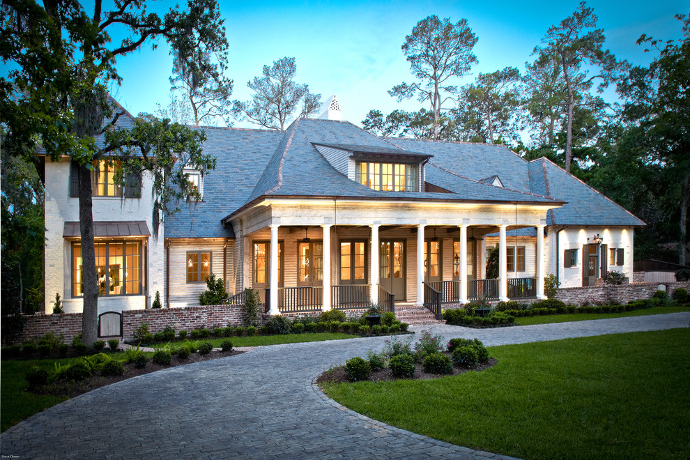 Imagen de fachada de casa beige clásica de tamaño medio de dos plantas con revestimiento de ladrillo, tejado a cuatro aguas y tejado de teja de madera