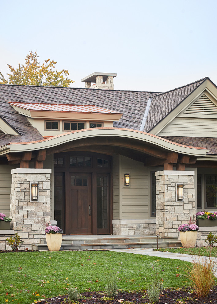 Réalisation d'une façade de maison beige tradition en panneau de béton fibré de plain-pied avec un toit à deux pans et un toit mixte.