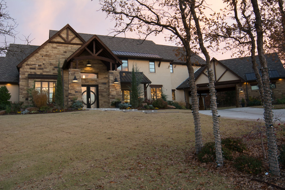 Example of a large arts and crafts beige two-story stucco exterior home design in Oklahoma City with a tile roof