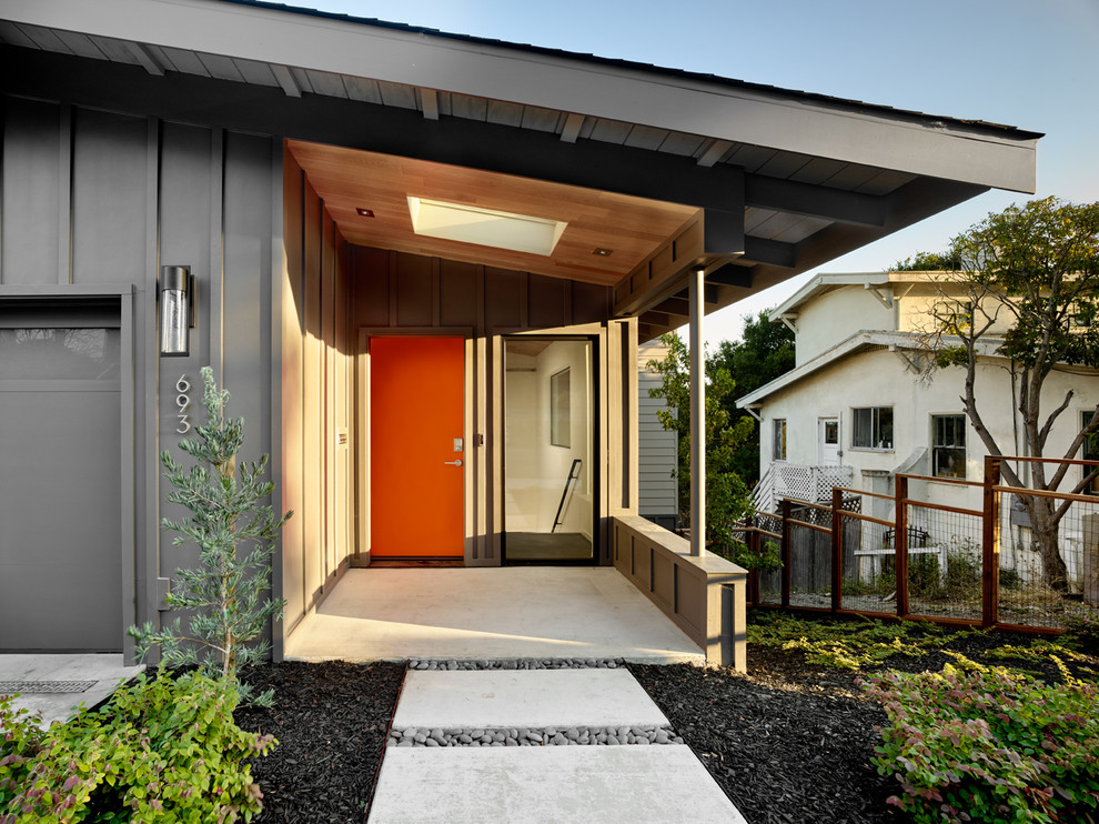 Diseño de fachada gris retro de tamaño medio de una planta con revestimientos combinados y tejado a dos aguas