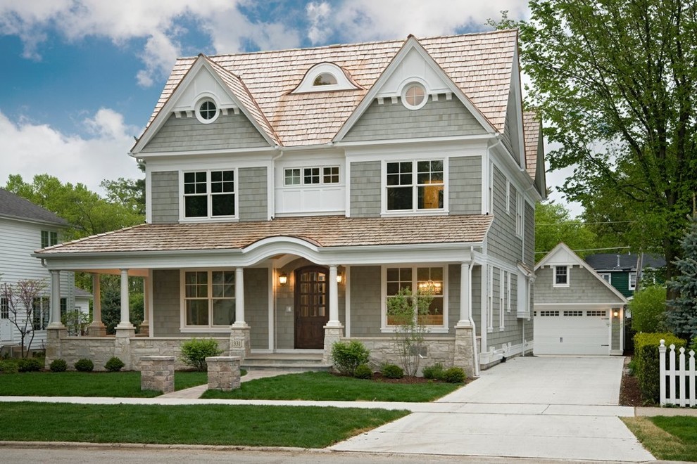 Medium sized and gey victorian house exterior in Chicago with three floors, wood cladding and a pitched roof.