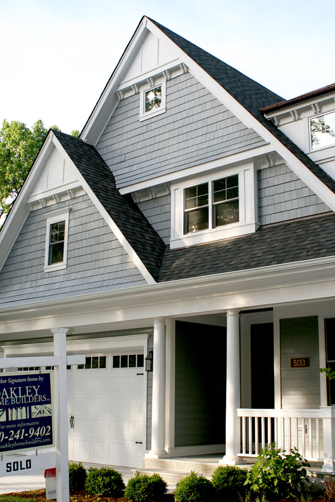 Modelo de fachada de casa gris tradicional de tamaño medio de dos plantas con revestimiento de madera, tejado a dos aguas y tejado de teja de madera