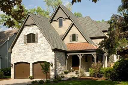 На фото: двухэтажный, бежевый дом среднего размера в классическом стиле с комбинированной облицовкой и двускатной крышей