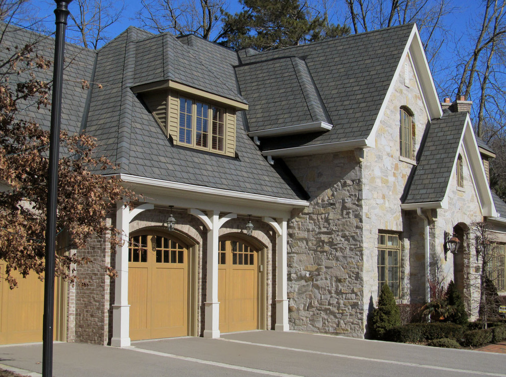 Imagen de fachada de casa beige clásica de tamaño medio de dos plantas con revestimiento de piedra, tejado a cuatro aguas y tejado de teja de madera