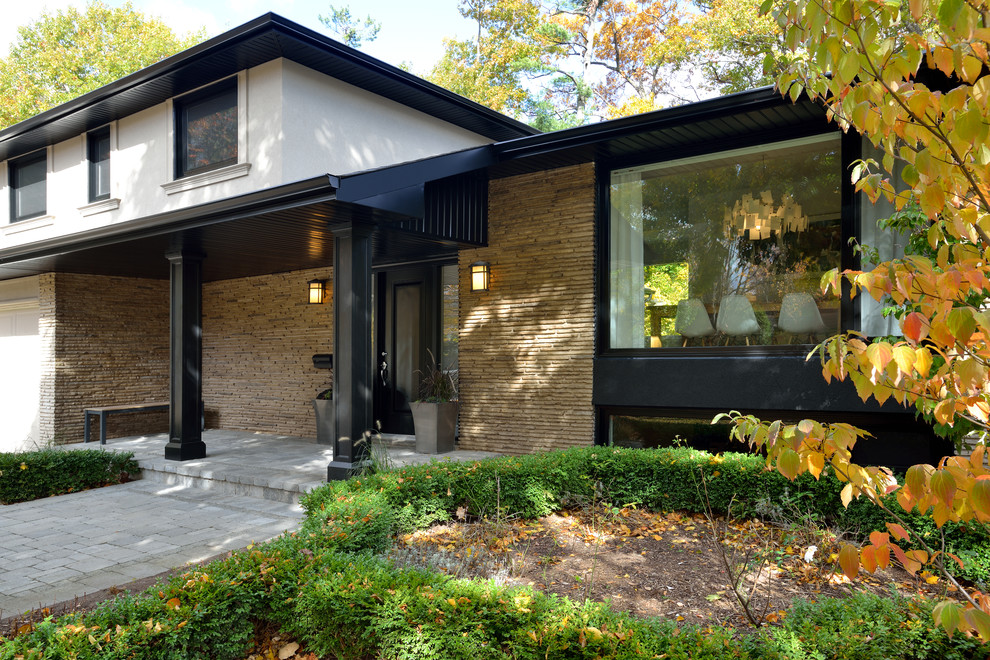 This is an example of a large contemporary two floor detached house in Toronto with mixed cladding and a hip roof.