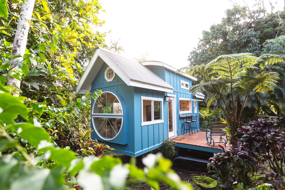 Foto della villa piccola blu stile marinaro a due piani con rivestimento in legno, tetto a capanna e copertura in metallo o lamiera