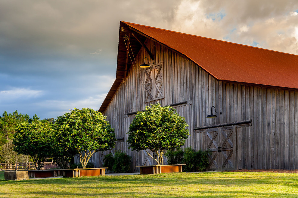 Foto de fachada gris rural grande de una planta con revestimiento de madera y tejado a doble faldón