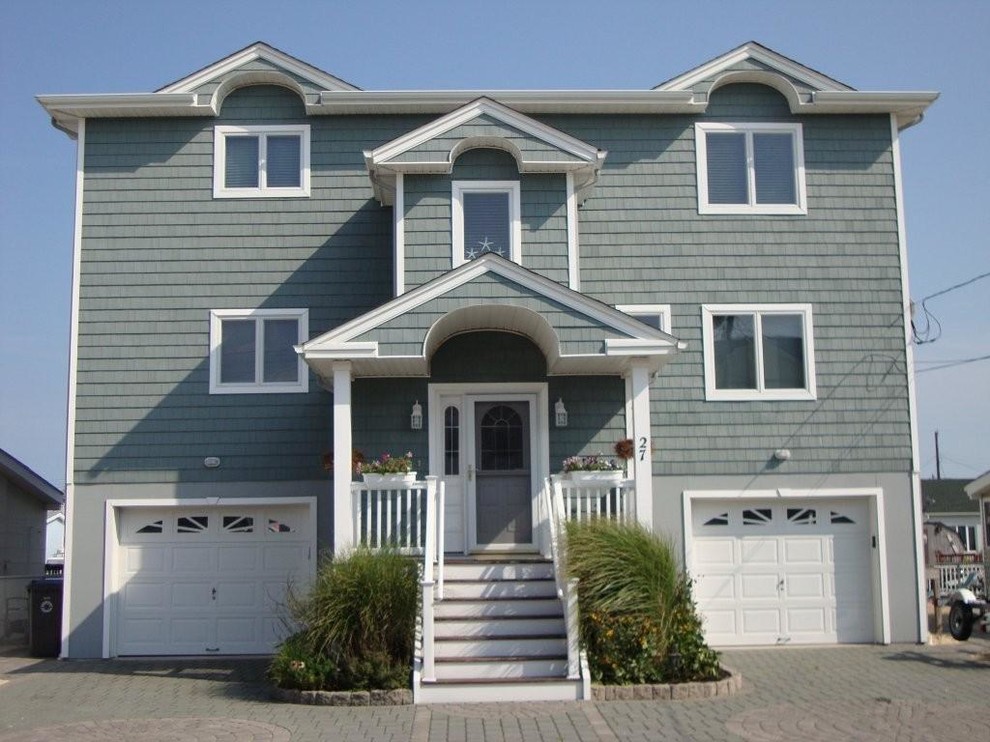 Cette photo montre une façade de maison bord de mer de taille moyenne et à un étage avec un revêtement en vinyle.