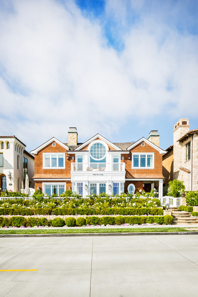 Zweistöckiges Maritimes Haus mit brauner Fassadenfarbe, Satteldach und Schindeldach in Orange County