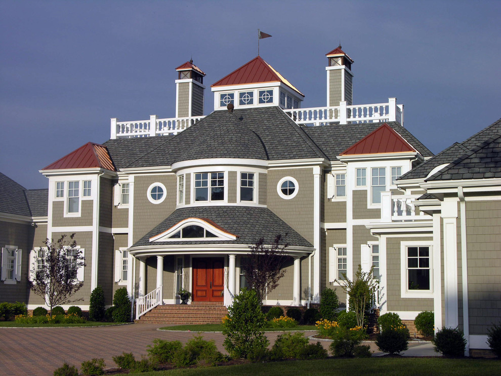 На фото: большой, коричневый, трехэтажный, деревянный частный загородный дом в морском стиле с вальмовой крышей и крышей из гибкой черепицы с