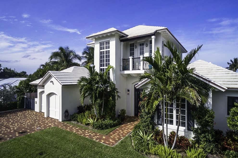 Idee per la facciata di una casa grande bianca tropicale a due piani con rivestimento in stucco e tetto a capanna