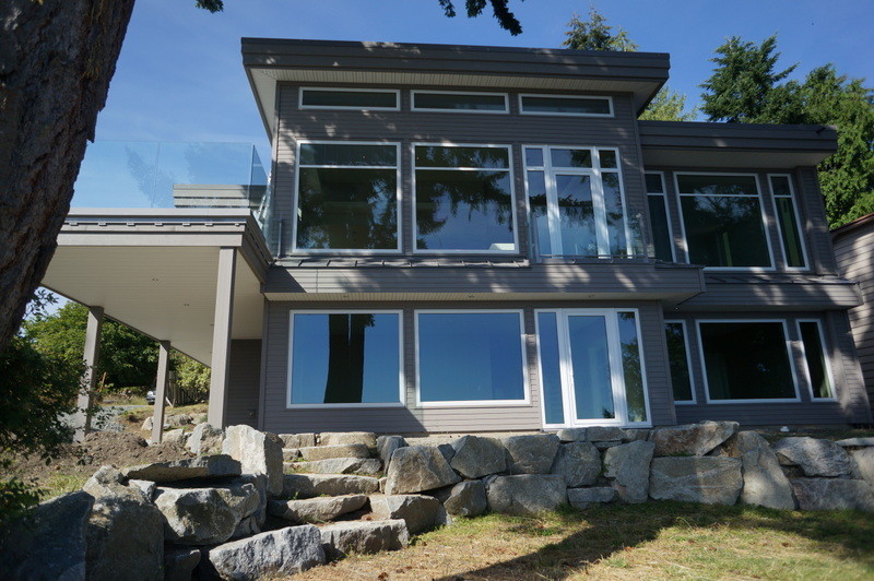Photo of a large and gey contemporary two floor house exterior in Vancouver with concrete fibreboard cladding.