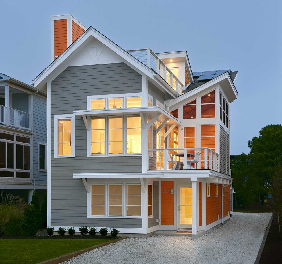 This is an example of a large and gey coastal house exterior in Other with a pitched roof, three floors and mixed cladding.