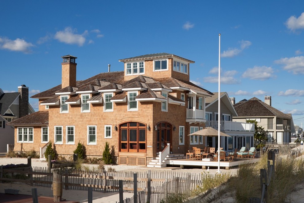 Esempio della facciata di una casa grande marrone stile marinaro a tre piani con rivestimento in legno