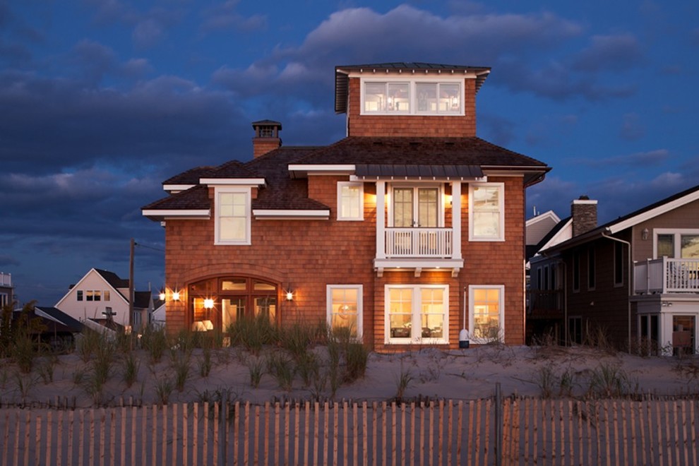 Foto della facciata di una casa grande marrone stile marinaro a tre piani con rivestimento in legno