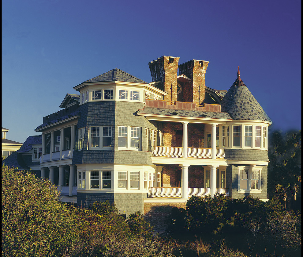 Immagine della facciata di una casa grande blu vittoriana a tre piani con rivestimento in legno