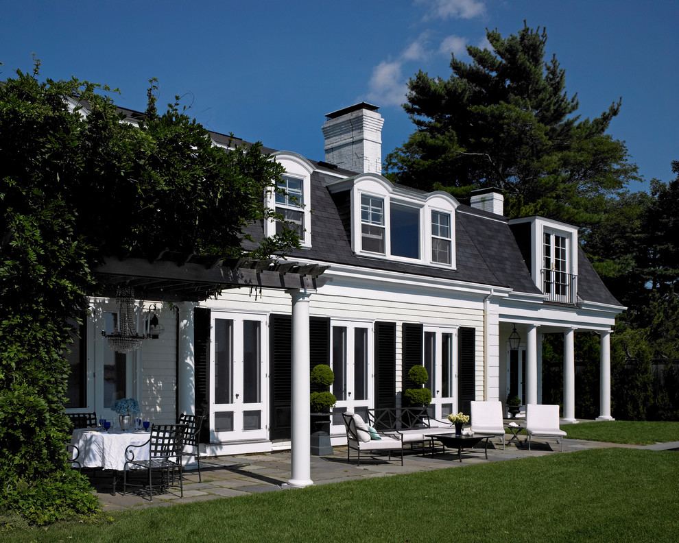 This is an example of a medium sized and white classic two floor house exterior in Boston with wood cladding.