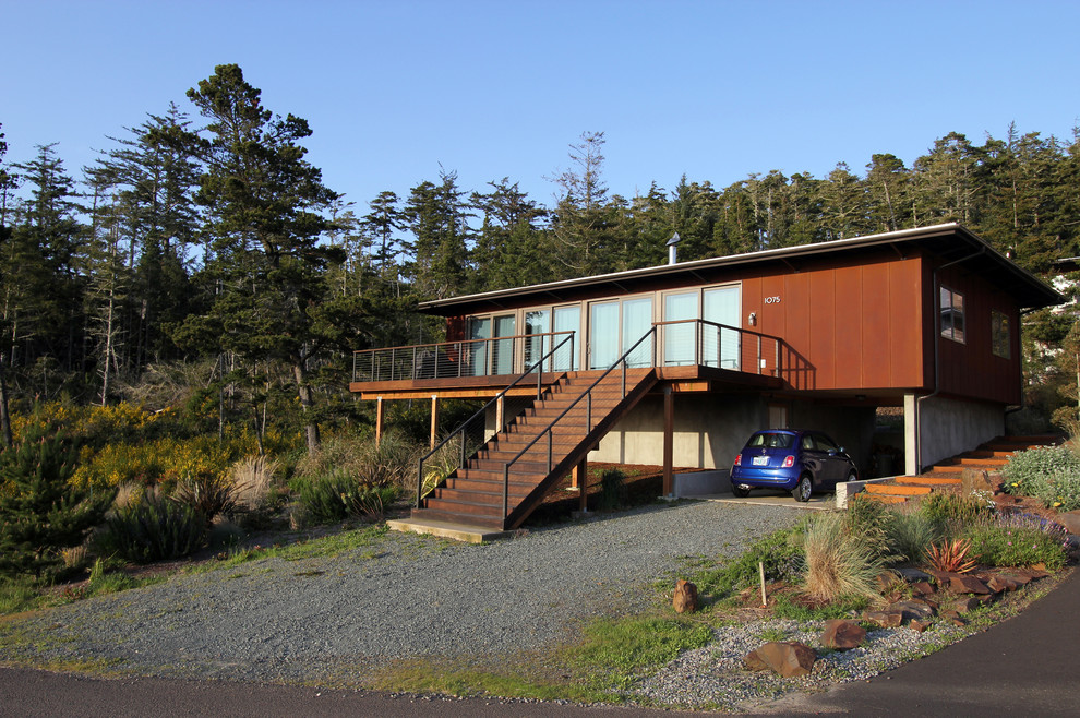 На фото: маленький, одноэтажный дом в стиле модернизм с облицовкой из металла и плоской крышей для на участке и в саду