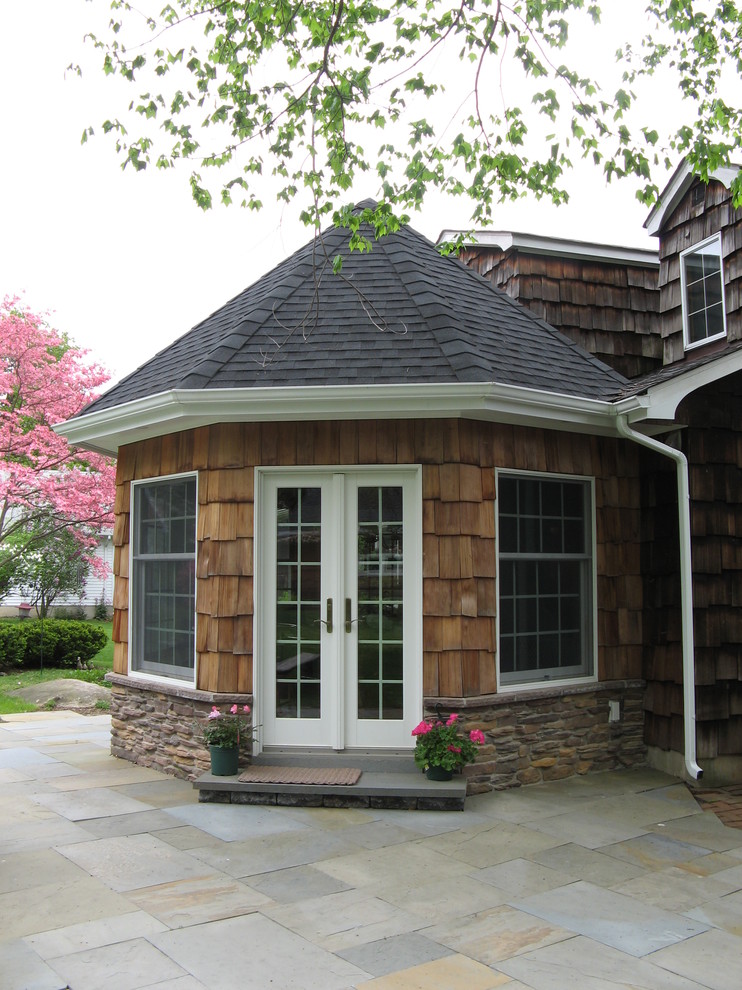Diseño de fachada de casa marrón con revestimiento de madera y tejado de teja de madera