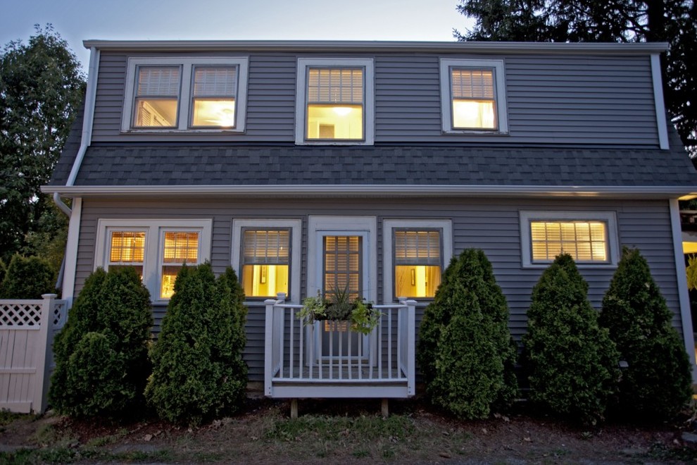 Пример оригинального дизайна: двухэтажный, серый дом в классическом стиле с облицовкой из винила